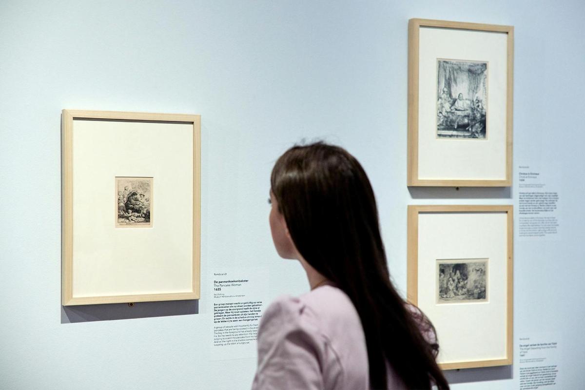 a woman looking at a display at an art exhibit