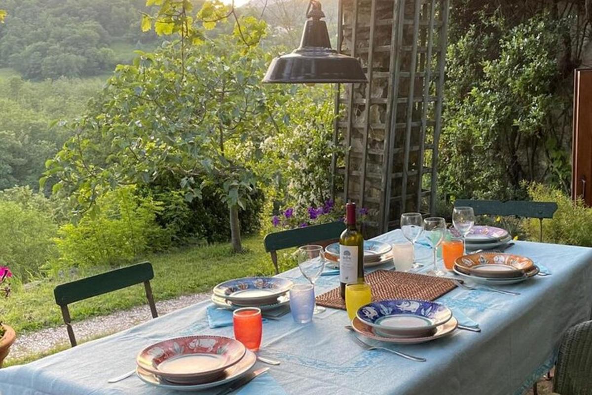 un tavolo con piatti, bicchieri e una bottiglia di vino