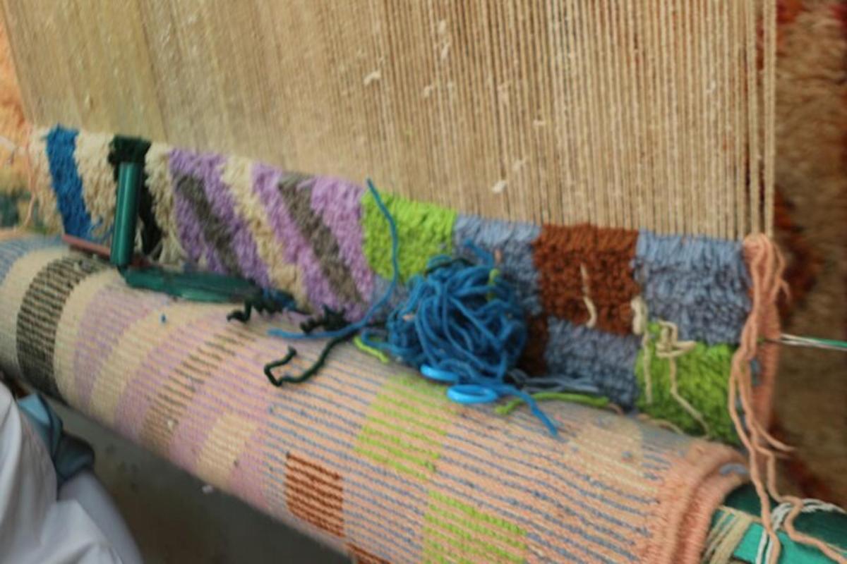 a close up of a couch with yarn and scissors on it