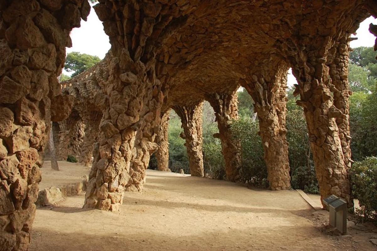 ein steinerner Torbogen in einem Park mit einer Steinmauer