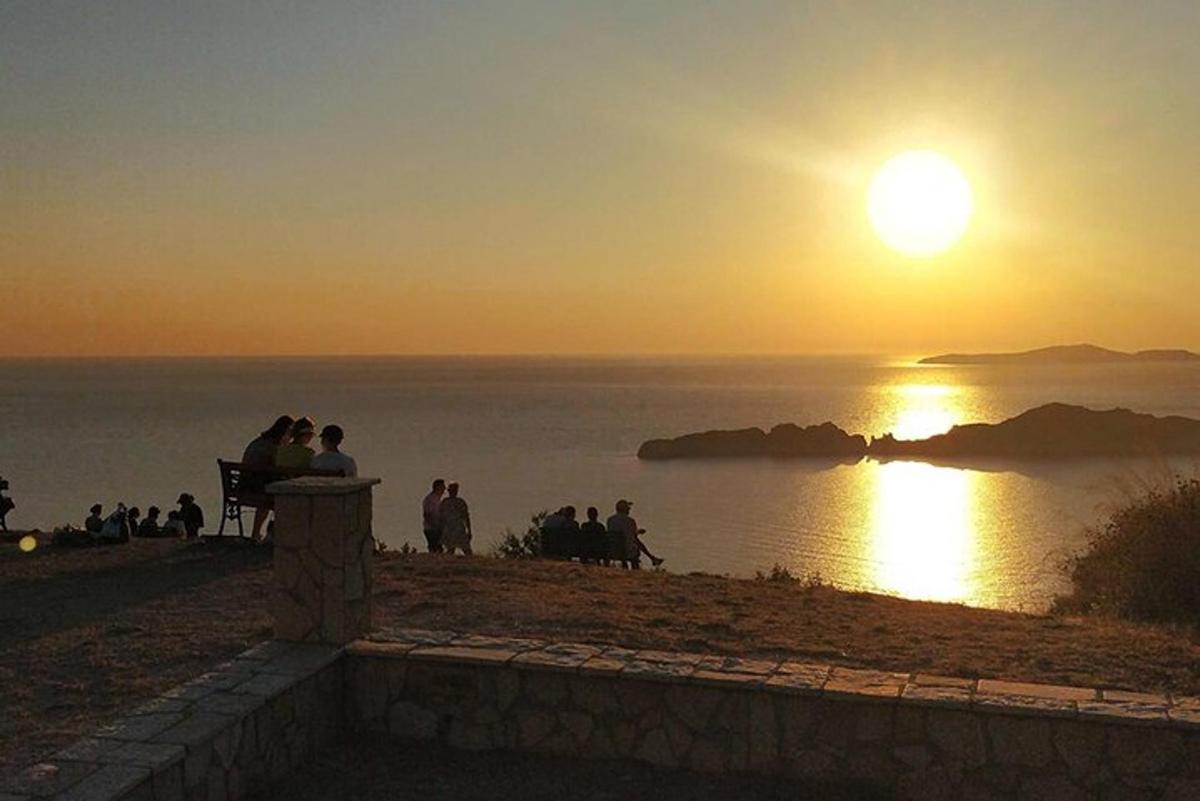 a group of people sitting on a bench watching the sunset