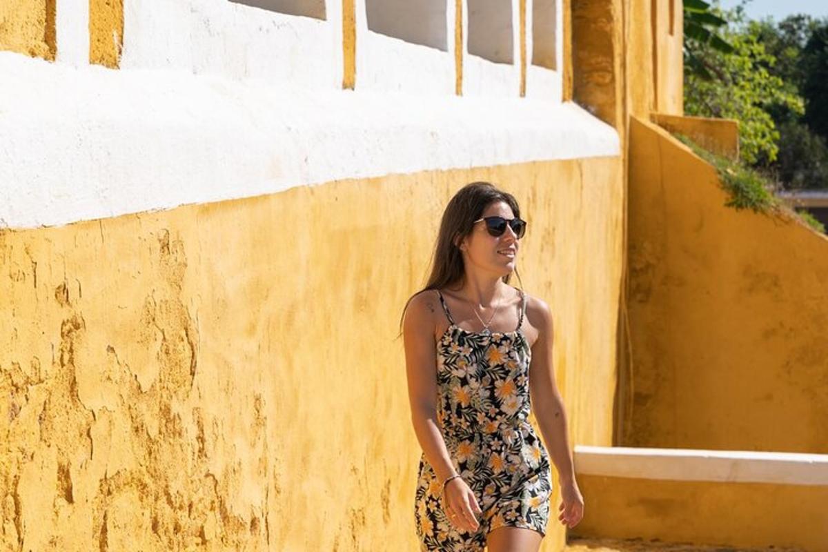 una donna in abito in piedi accanto a un muro giallo