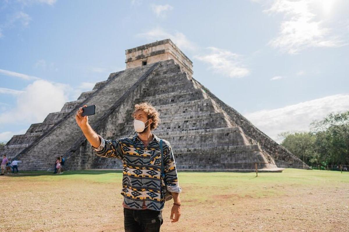 muž v masce stojící před pyramidou