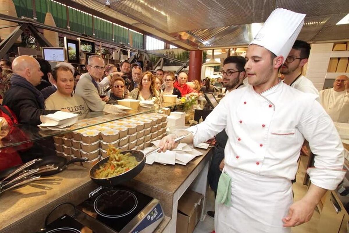 un xef dempeus a la cuina d'un restaurant preparant menjar