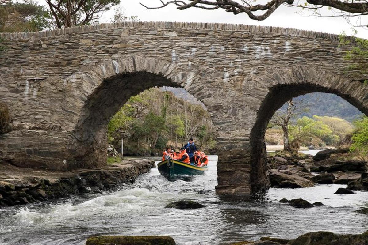 un grup de persones en una barca en un riu sota un pont