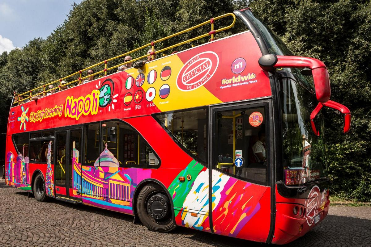 punane kahekordne buss sõidab mööda tänavat