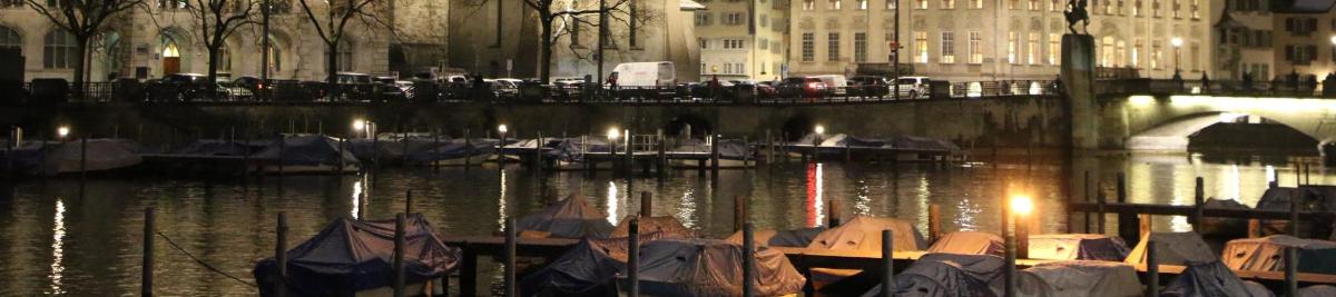 a group of boats docked in the water at night