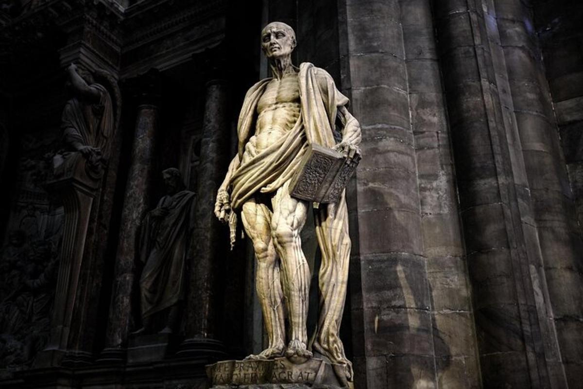 una statua di un uomo in piedi sul lato di un edificio