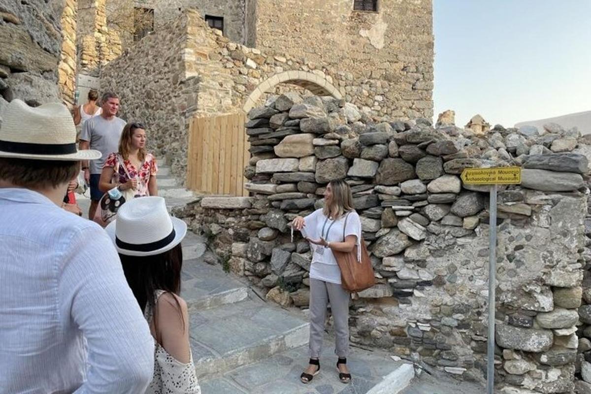 skupina lidí stojící vedle kamenné zdi