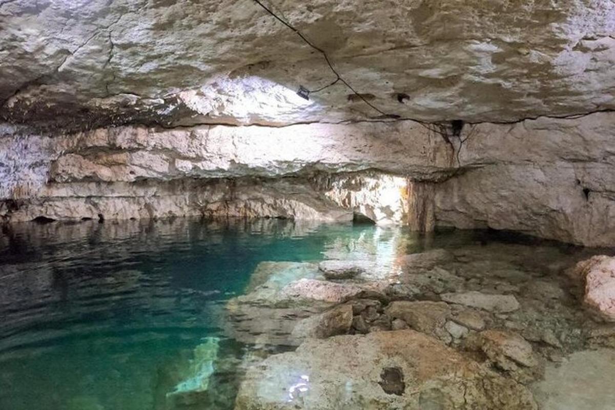 una grotta con una pozza d'acqua al suo interno