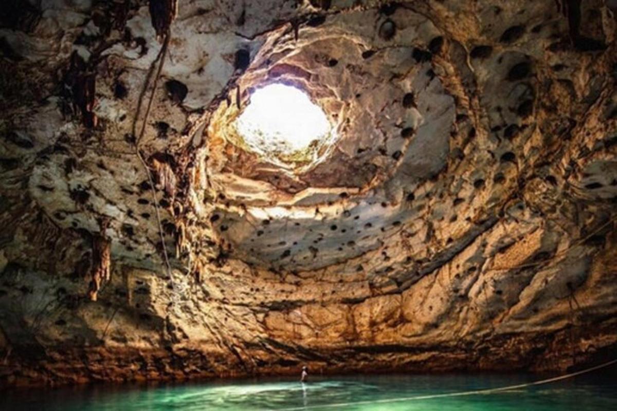 una grotta con una luce in mezzo all'acqua