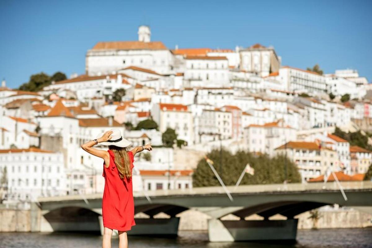 a woman in a red dress standing in front of a bridge