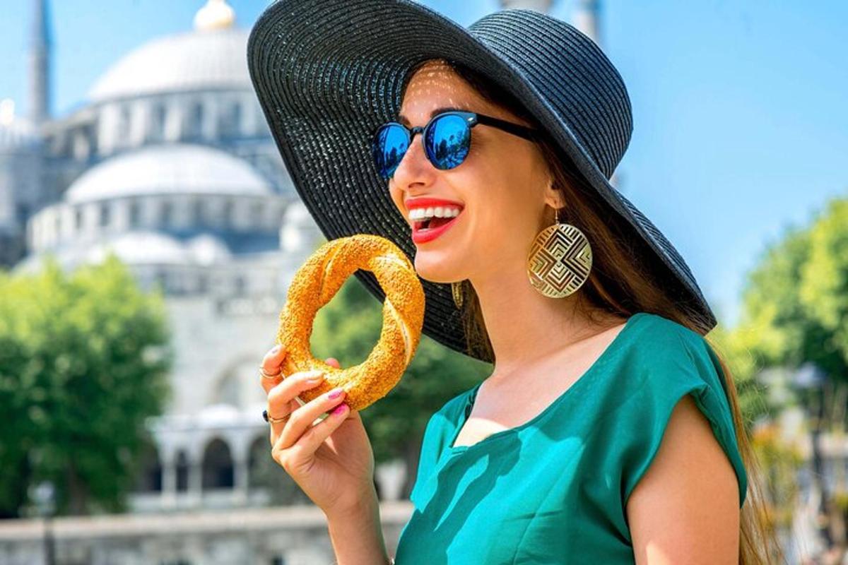 una donna sta mangiando un pretzel davanti a un edificio