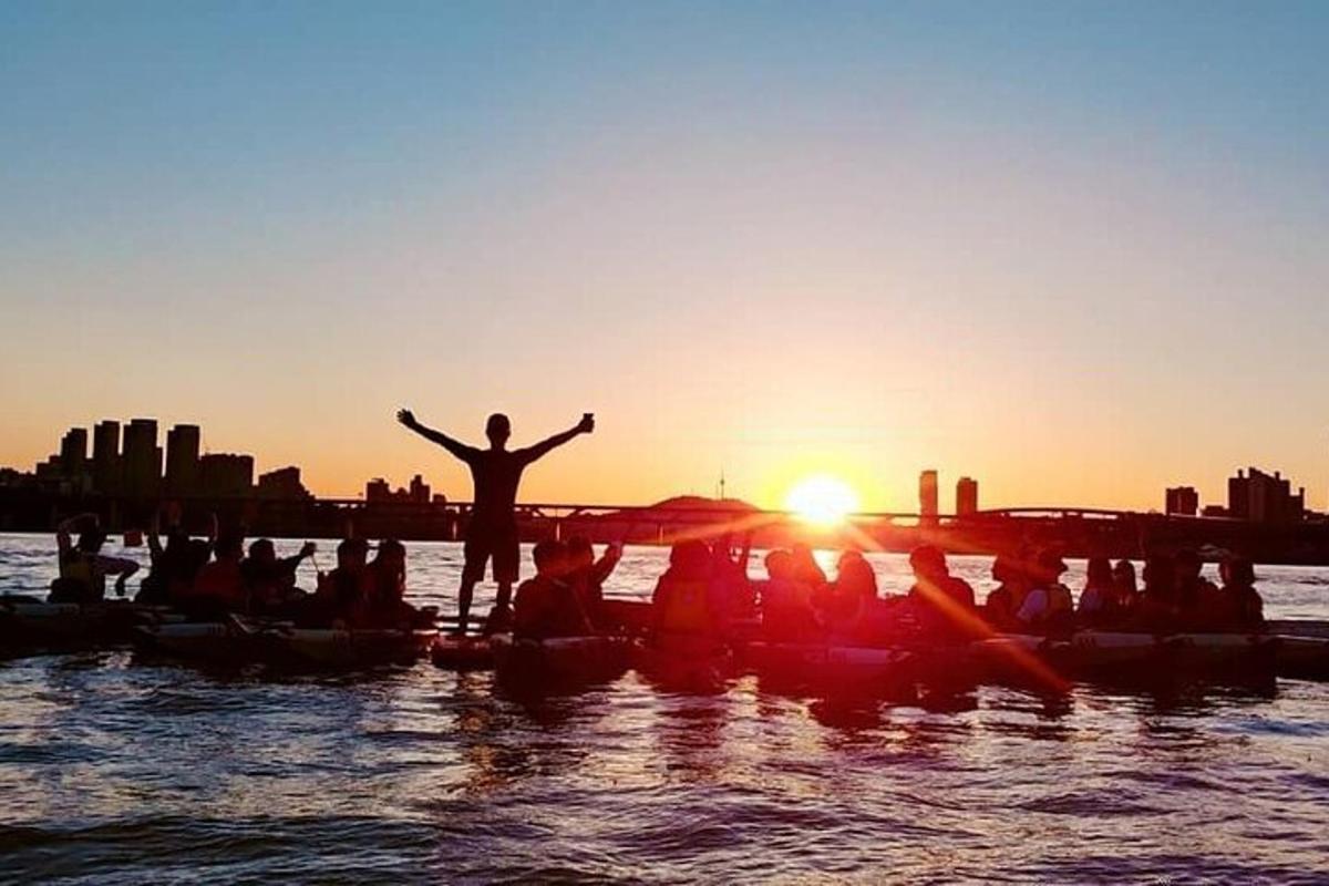 un gruppo di persone in canoa in acqua al tramonto