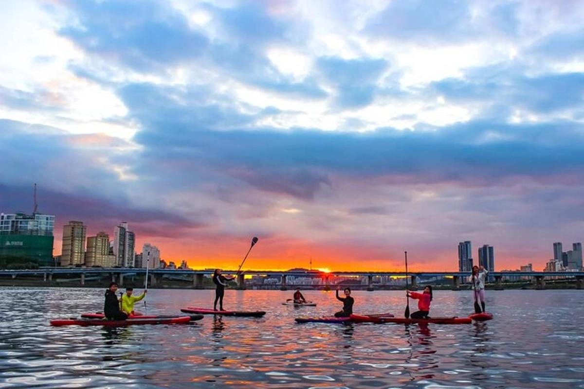 un gruppo di persone sui kayak in acqua al tramonto
