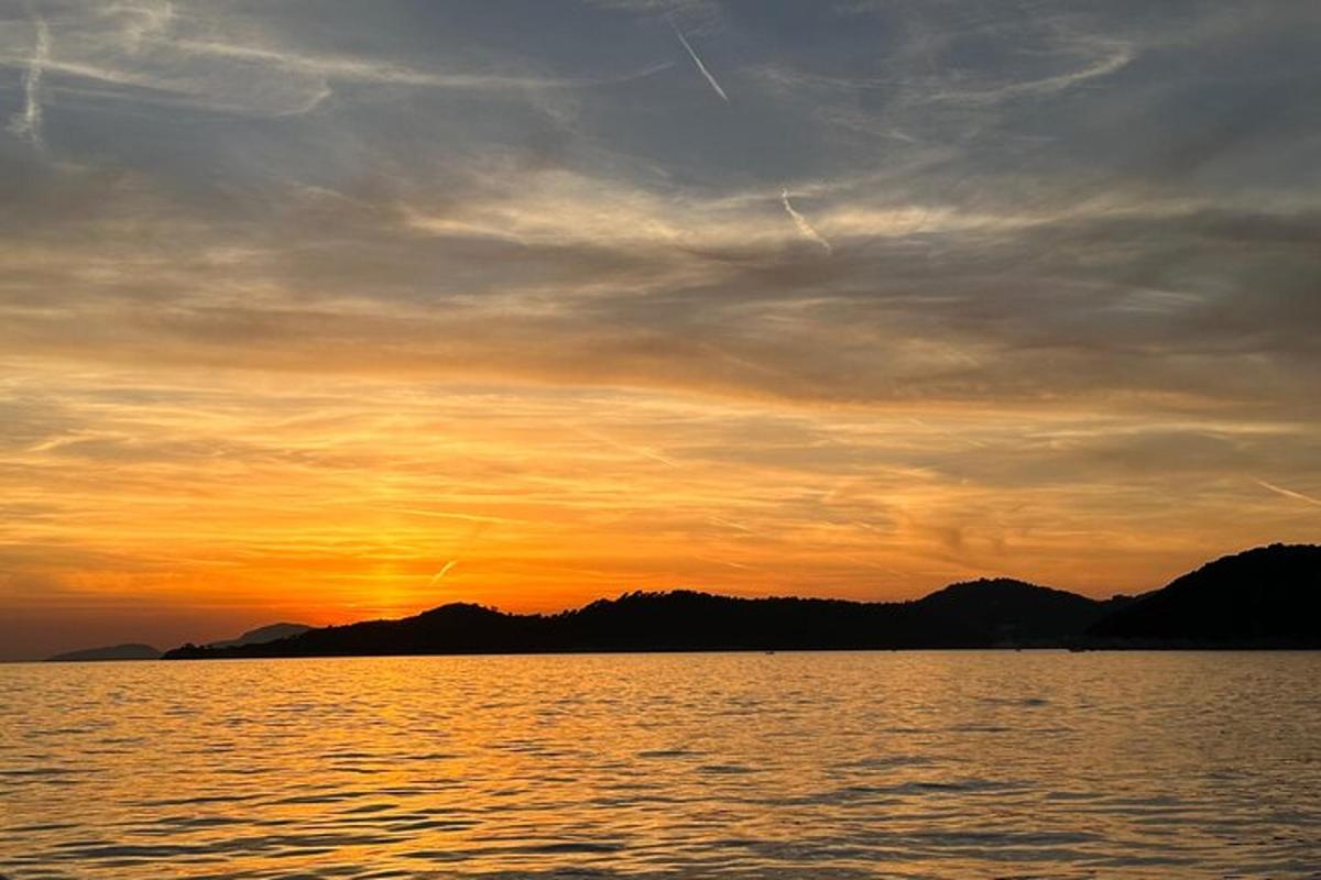 un tramonto su uno specchio d'acqua con montagne