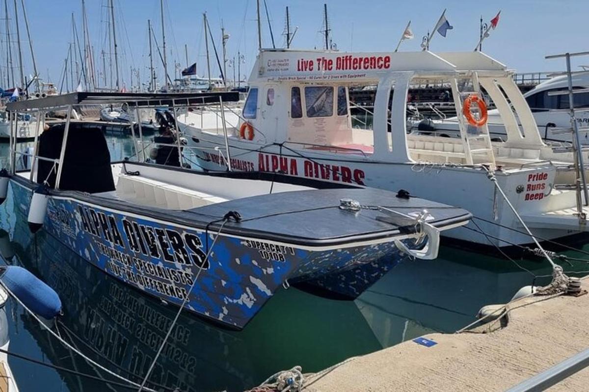 Un barco está atracado en un muelle de un puerto deportivo.