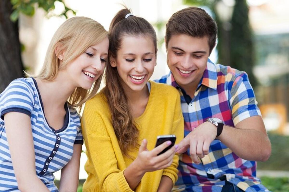 egy három emberből álló csoport mobiltelefont nézeget