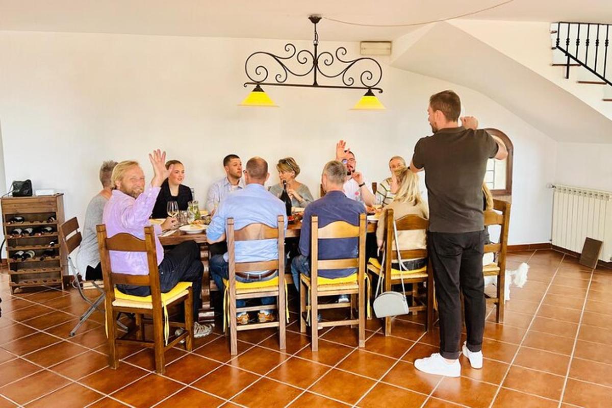 a man standing in front of a group of people sitting around a table