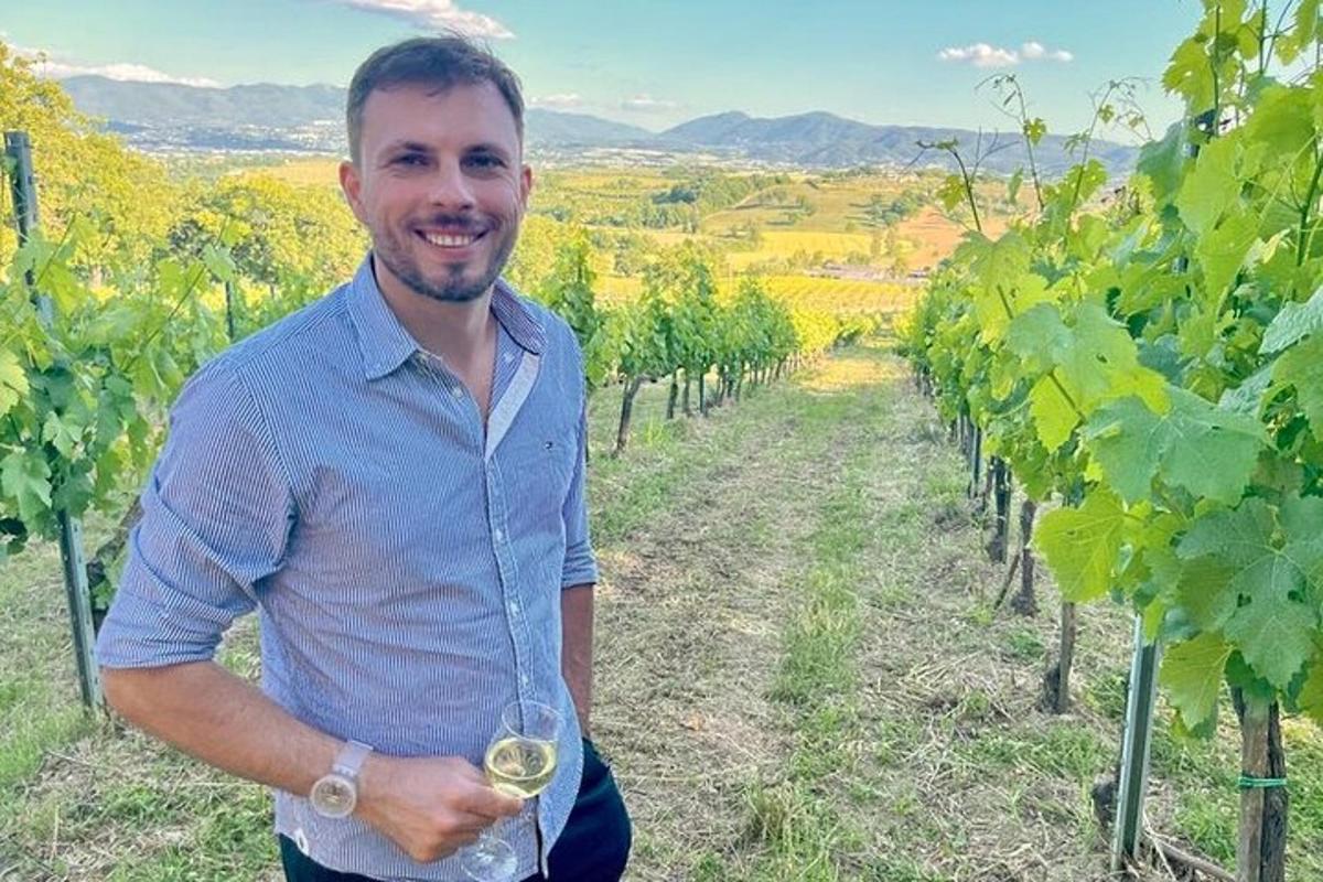 a man holding a wine glass in a vineyard