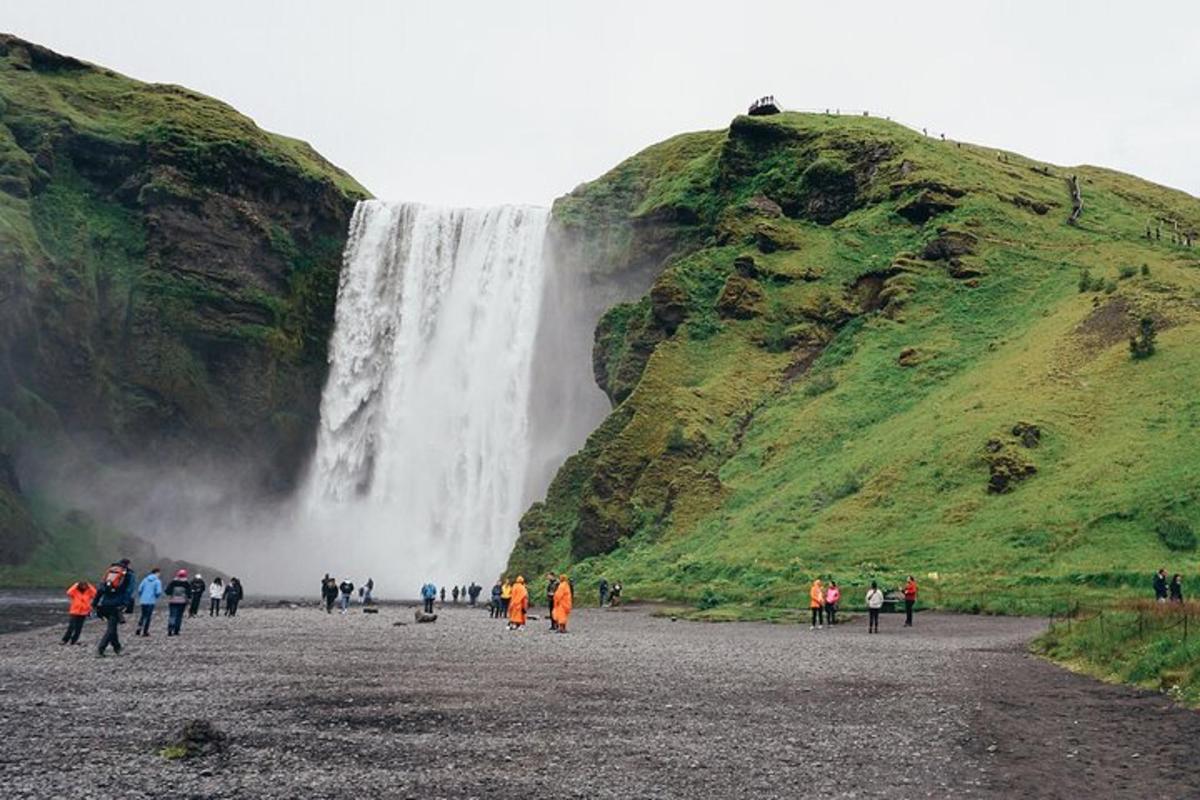 a group of people standing in front of a waterfall
