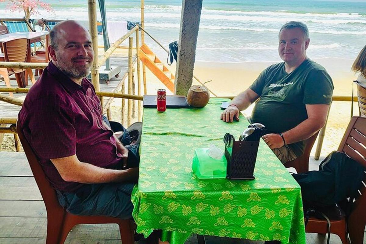 dos hombres sentados en una mesa en la playa