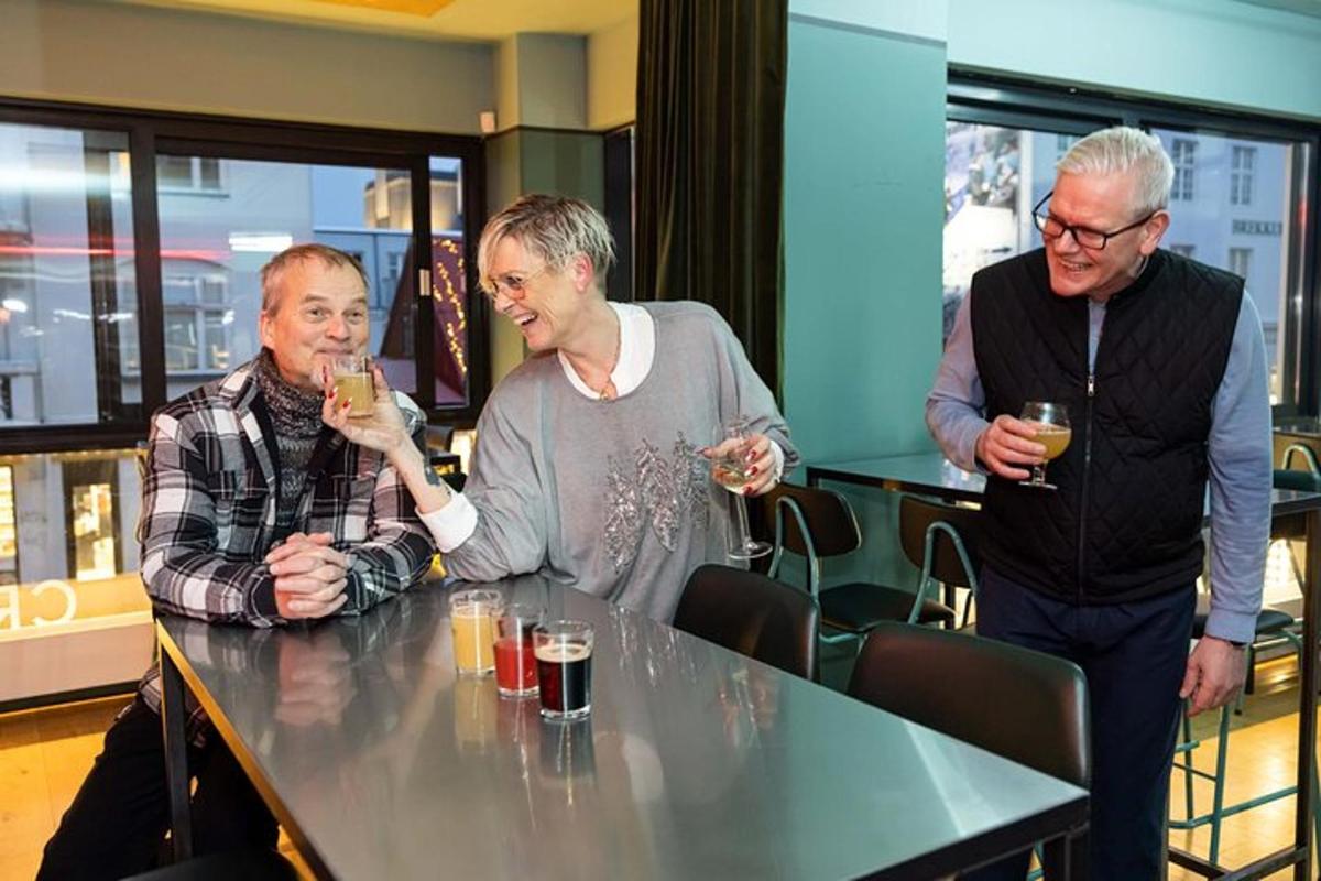 kolmest mehest koosnev grupp istub laua taga jookidega