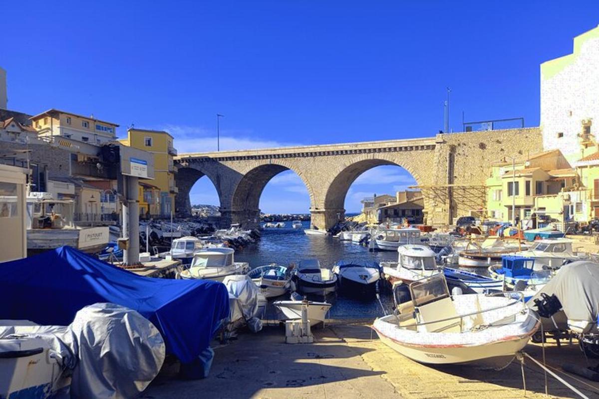 a group of boats docked in a harbor with a bridge