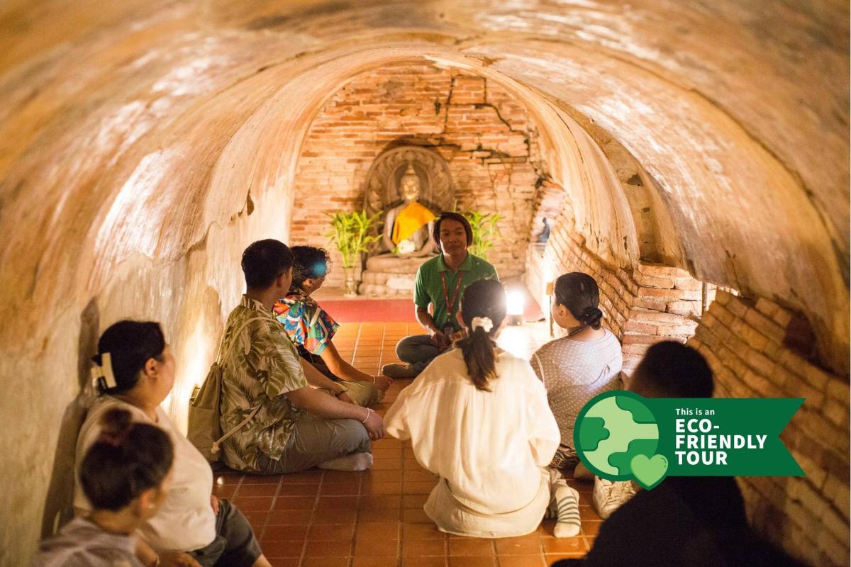un gruppo di persone sedute attorno a una statua in un tunnel