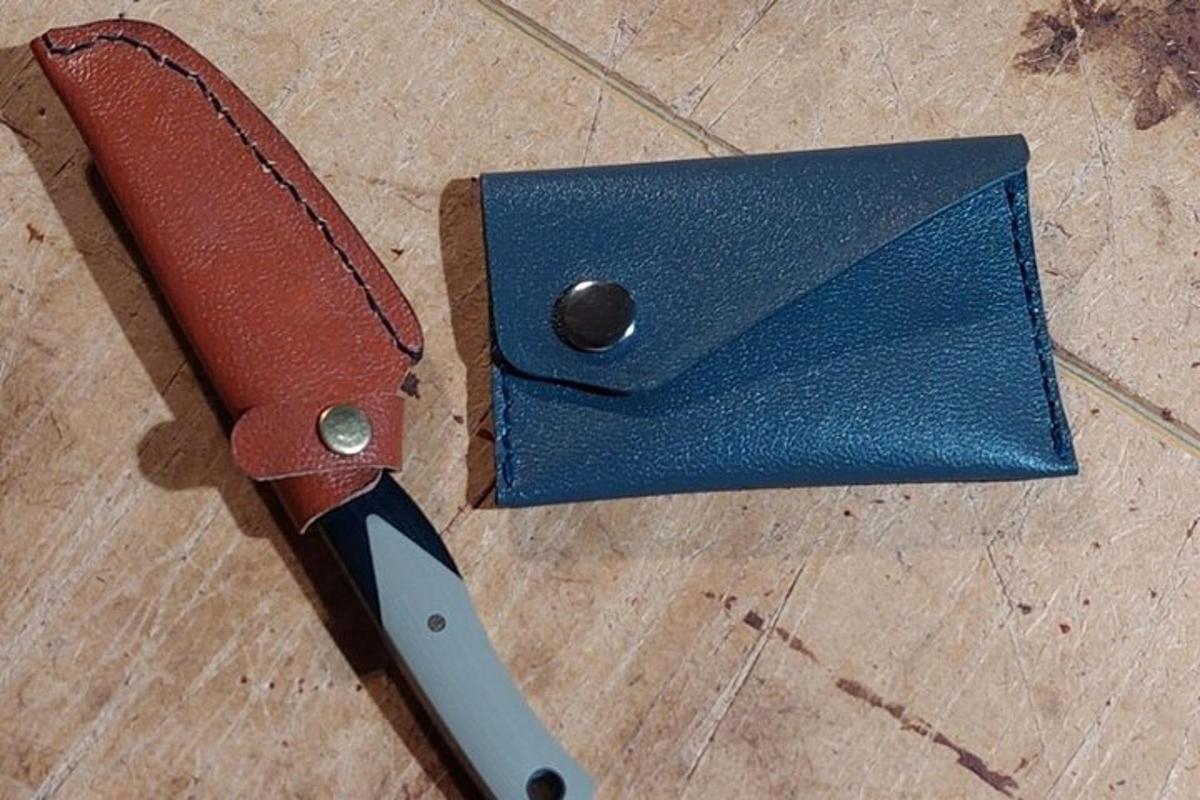 un coltello appoggiato sopra un portafoglio blu