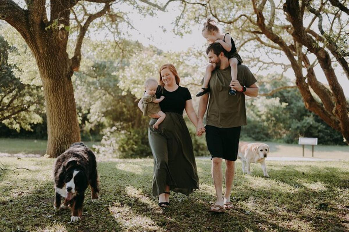 un uomo e una donna che camminano con un bambino e due cani