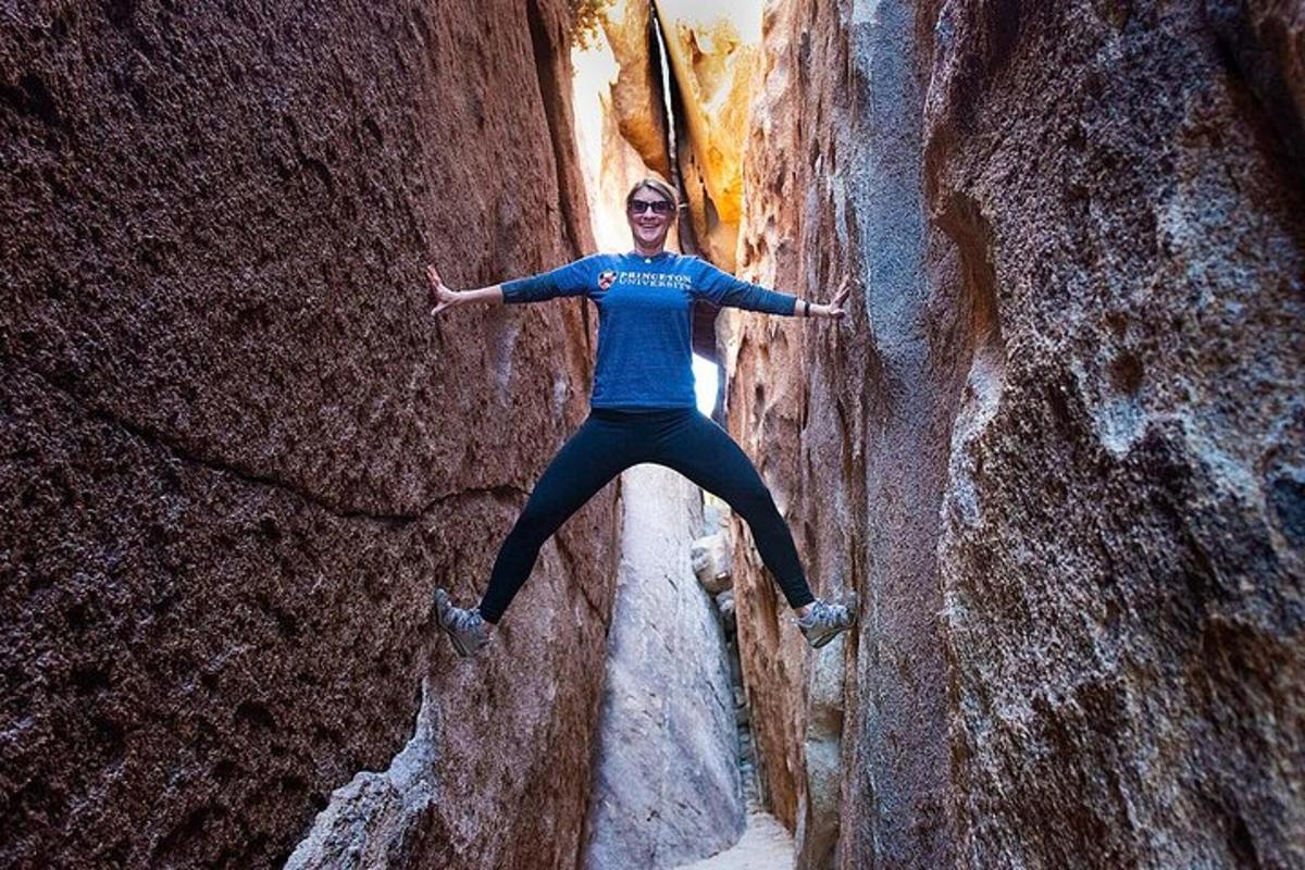 a woman is standing on a rock formation