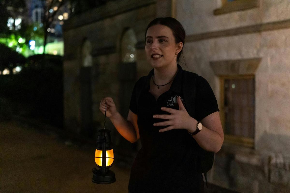 žena stojící vedle zapálené svíčky s lucernou