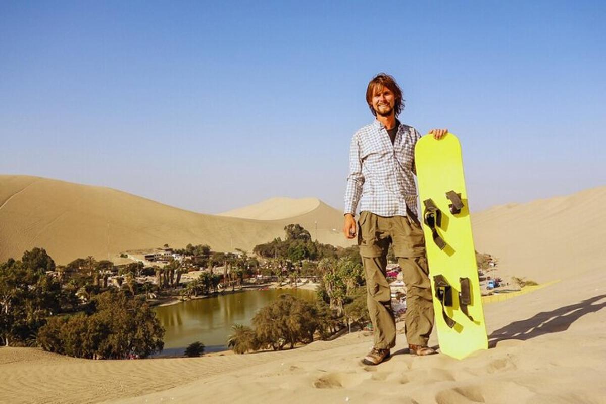 een man die in het zand staat met een snowboard in zijn handen