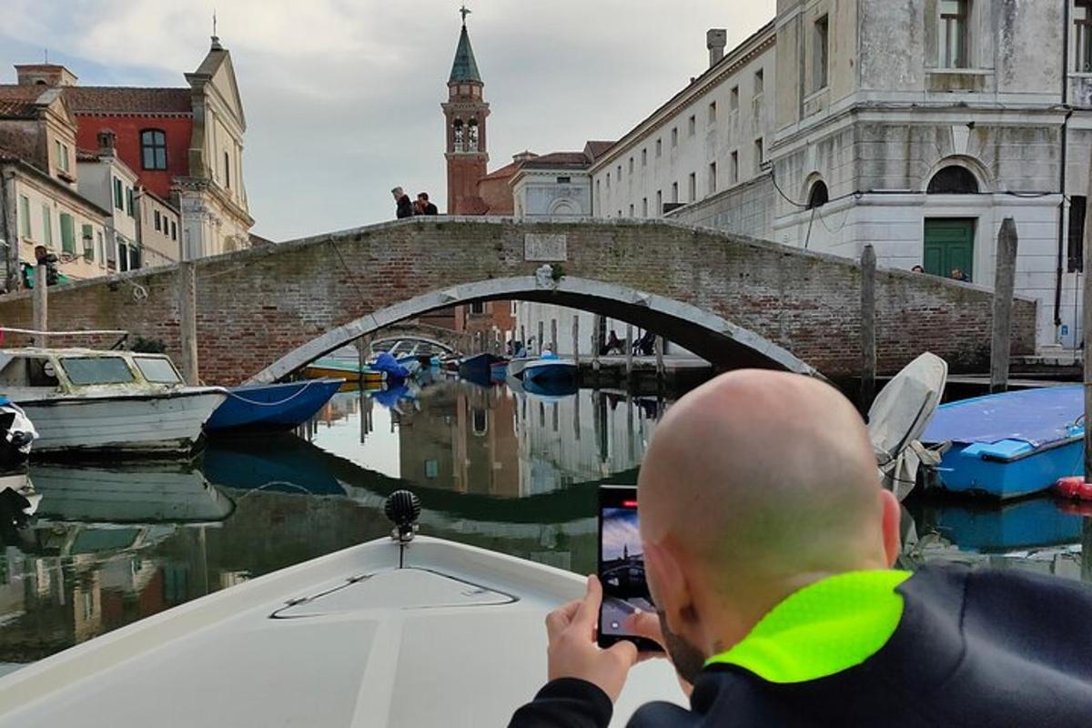 un uomo che scatta una foto di una barca in un canale