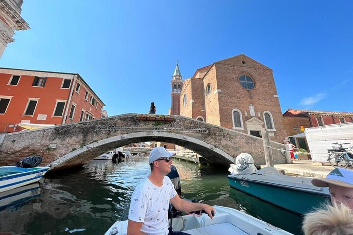 un uomo in barca su un canale con un ponte