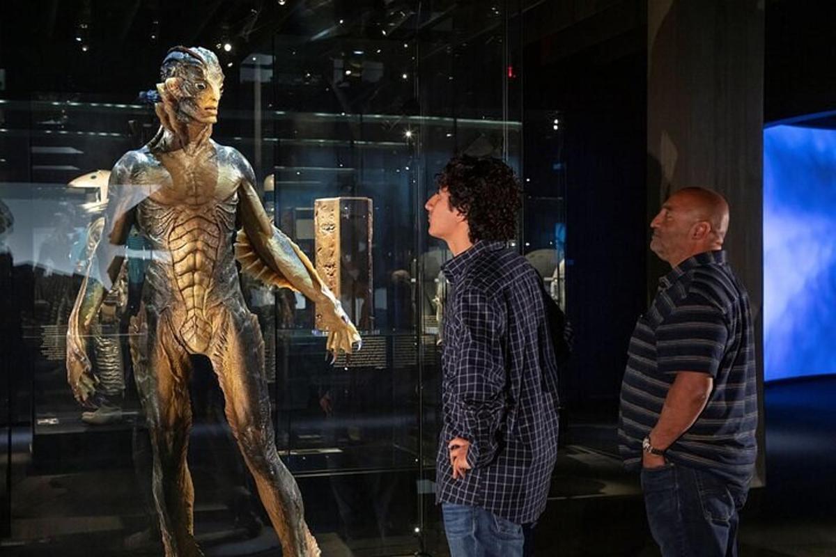 two men looking at a statue in a museum