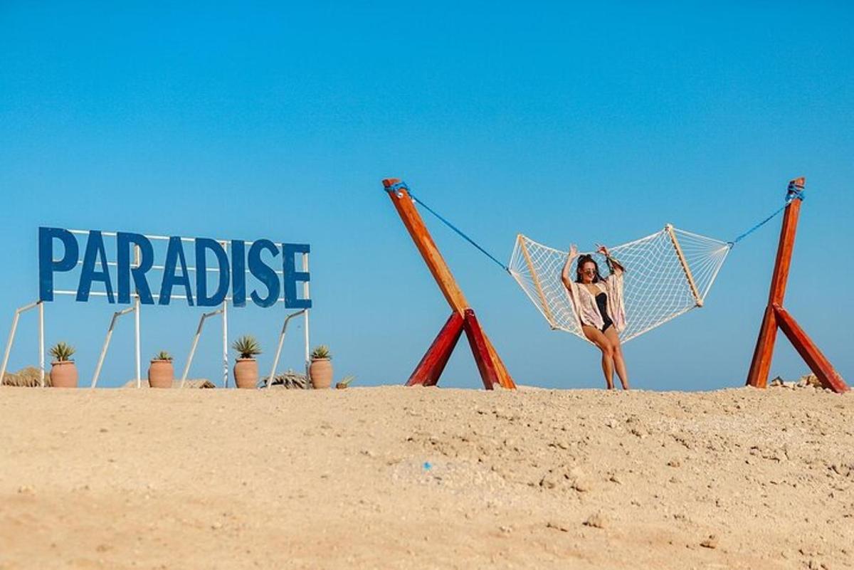 Una mujer está parada en una playa con una red de voleibol.