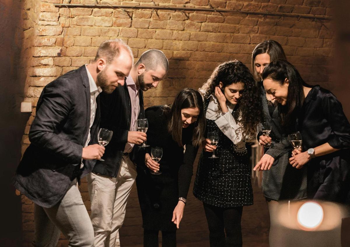 Un grupo de personas de pie juntas sosteniendo copas de vino.