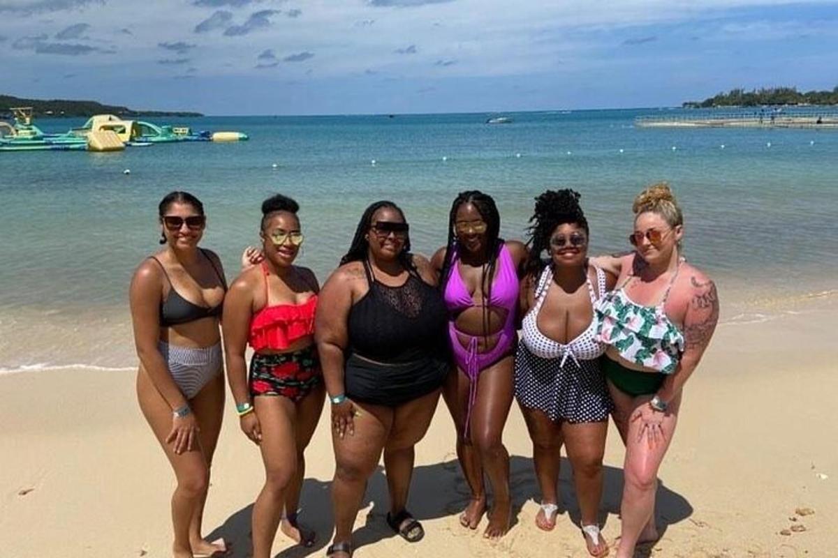 a group of women in bathing suits on a beach