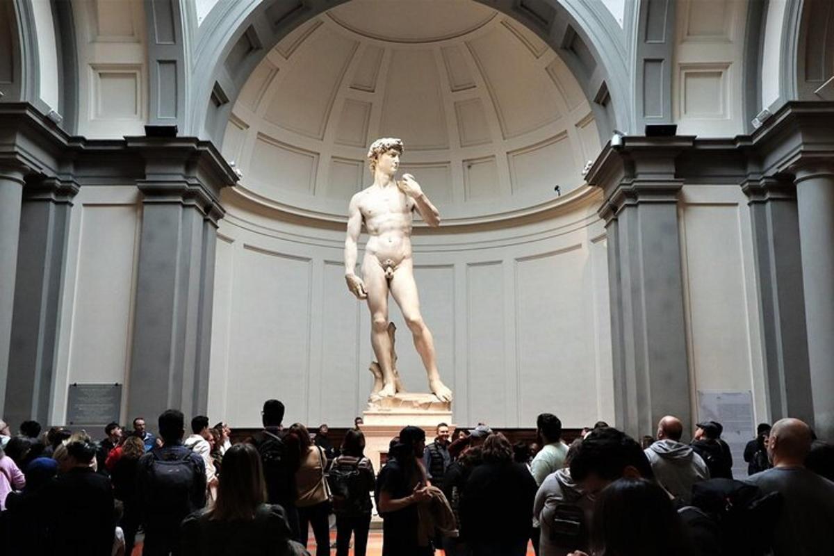 a crowd of people looking at a statue in a museum
