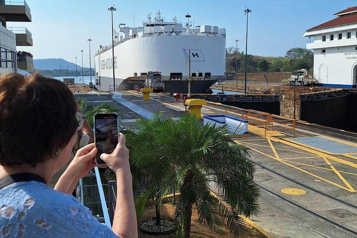 a person taking a picture of a ship with a cell phone