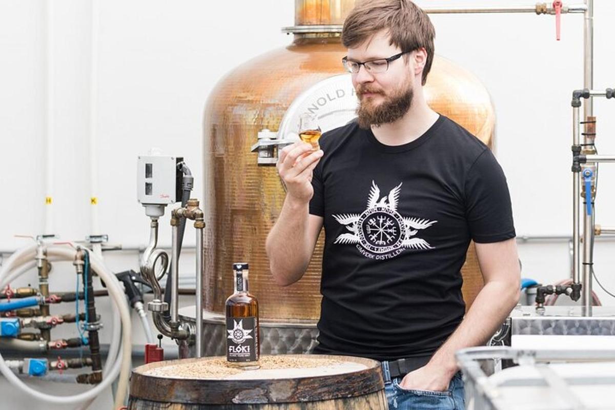 un uomo in piedi accanto a una bottiglia di whisky