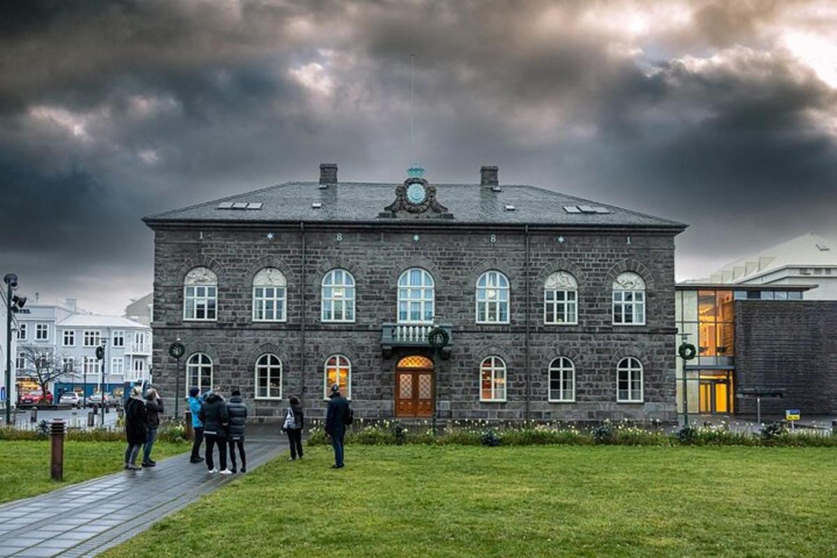 hópur fólks stendur fyrir framan stóra múrsteinsbyggingu