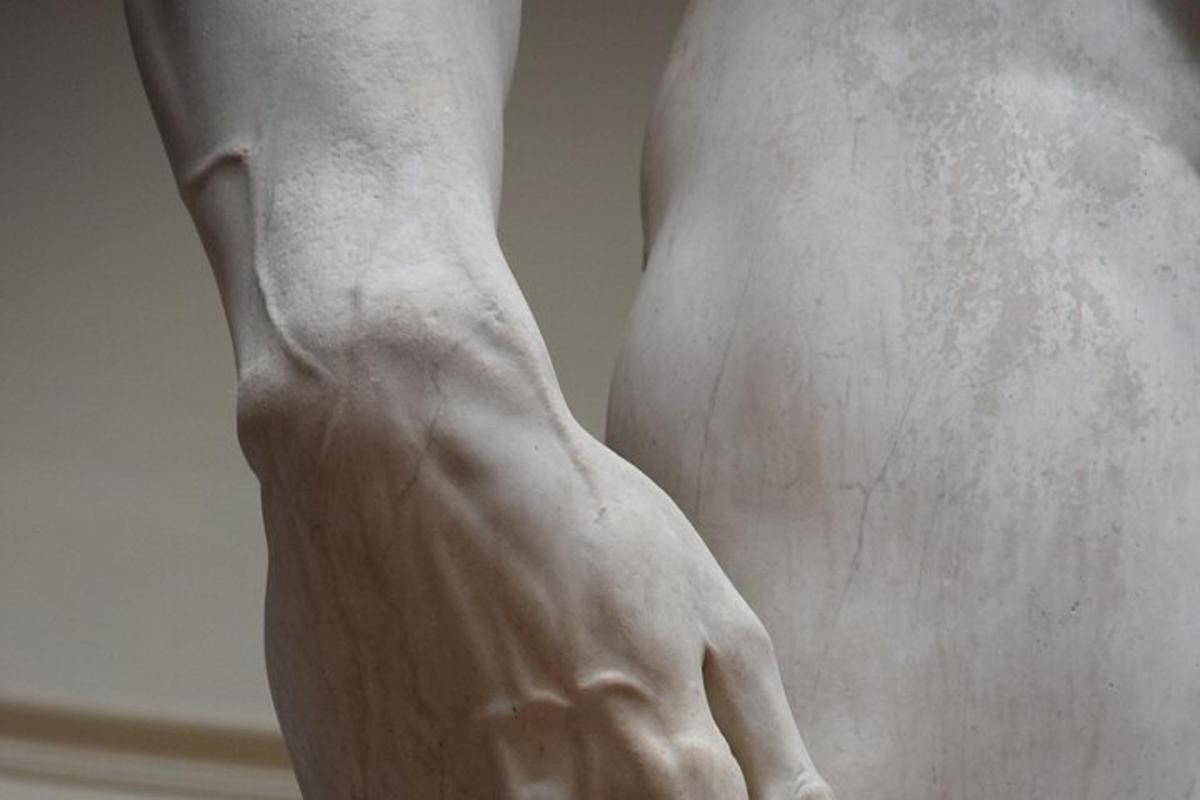 um close de uma estátua do braço de uma pessoa