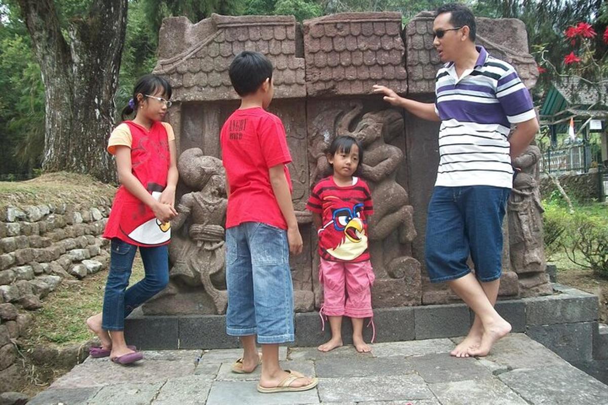 sekelompok anak berdiri di depan patung
