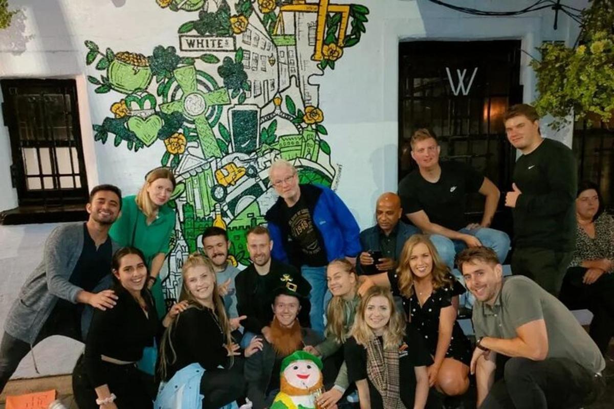 un gruppo di persone in posa per una foto davanti a un muro