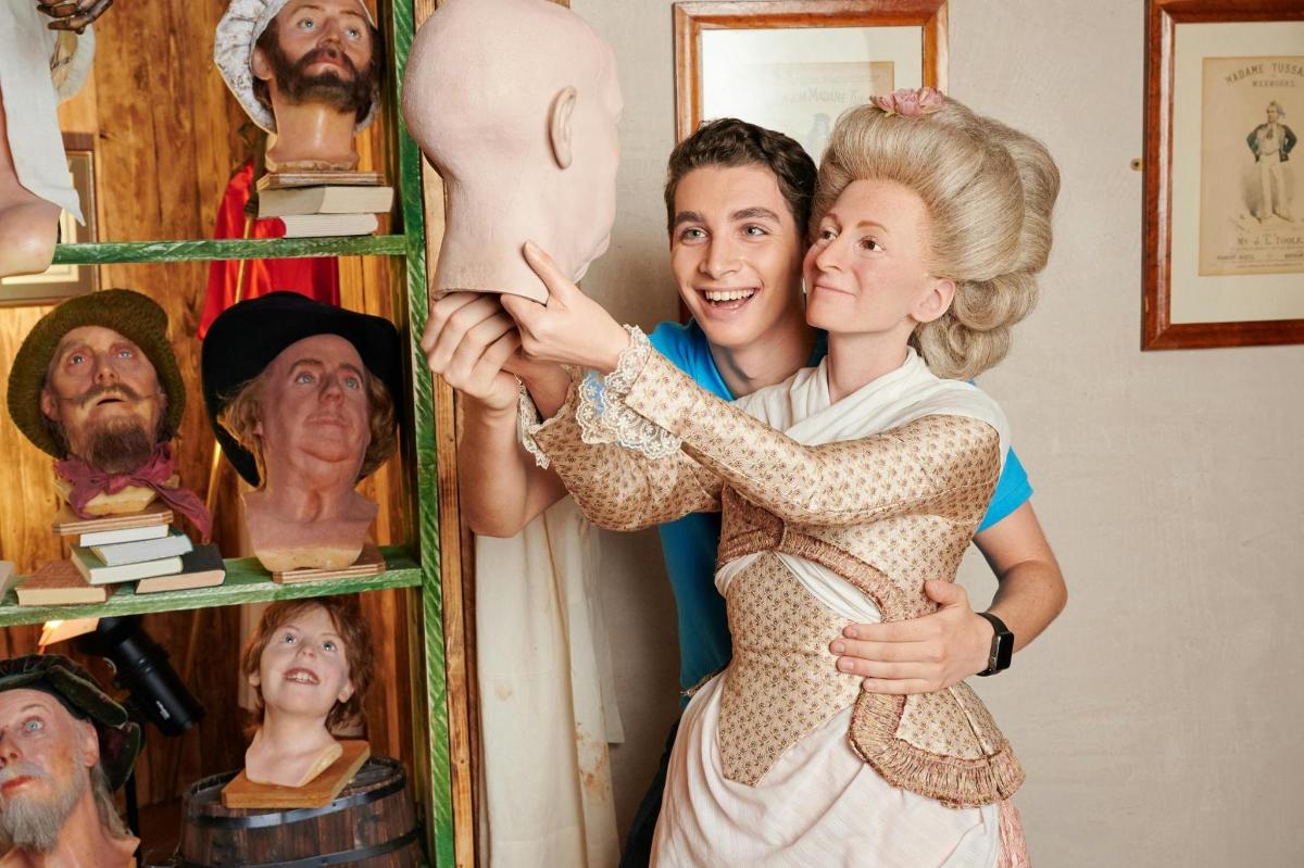 a man and a woman standing next to a dummy