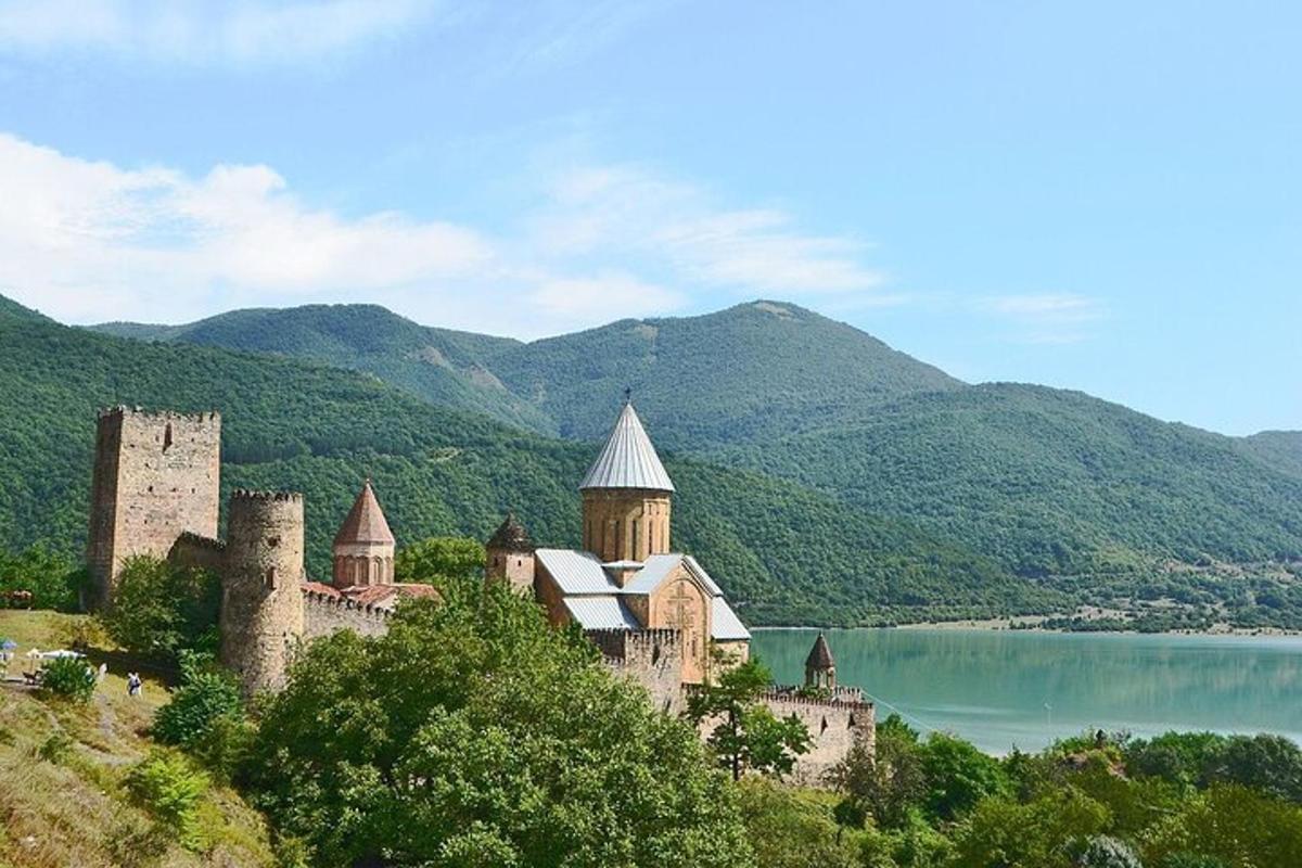 un castell en un turó al costat d'una massa d'aigua