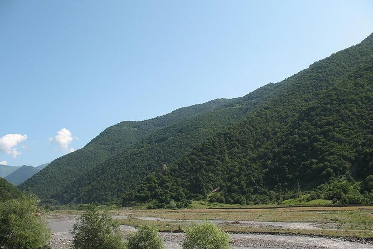 una montagna con un fiume di fronte